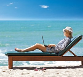 Young woman with laptop on the tropical beach